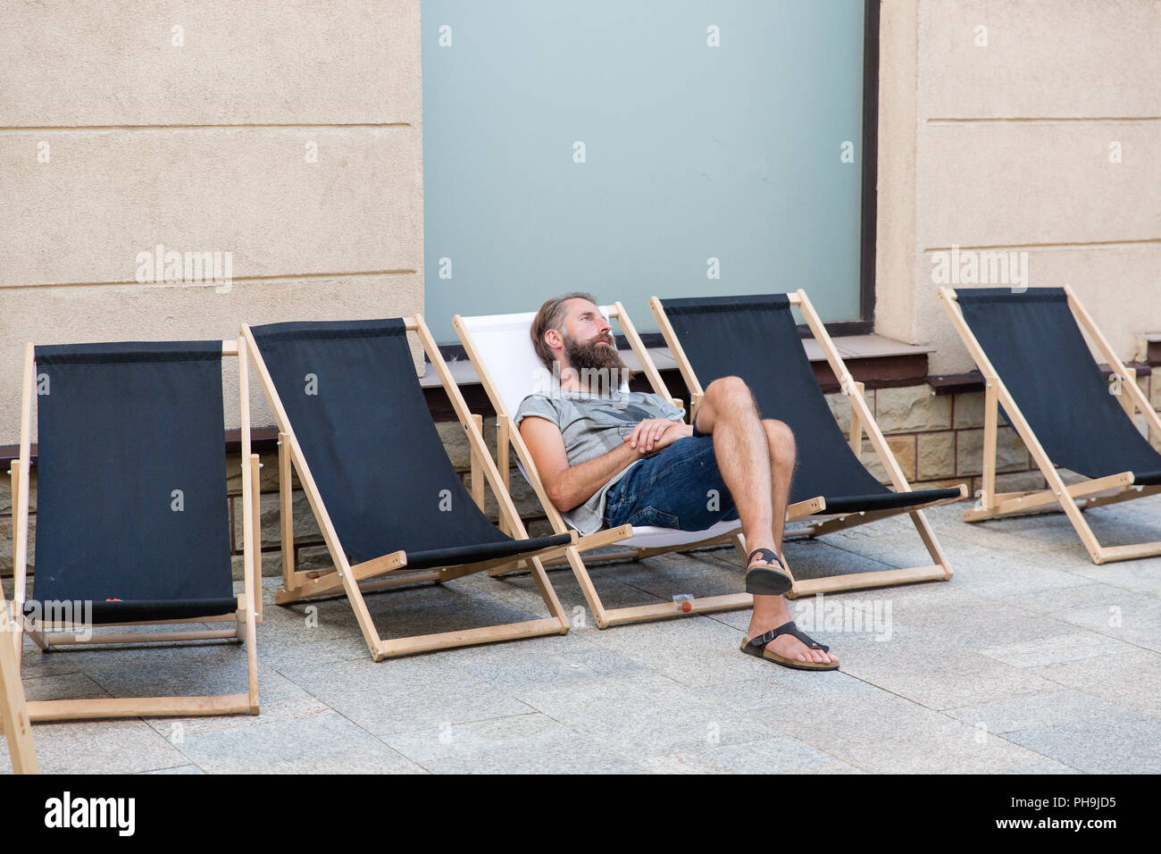 Mann mit einem Bart ausruhen und entspannen auf einem Liegestuhl in Krosno Polen Stockfoto