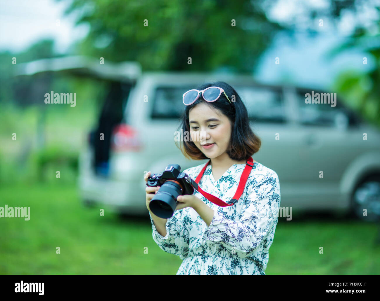 Happy Asian Girl Holding und Kontrolle Foto von der Kamera im Park Stockfoto