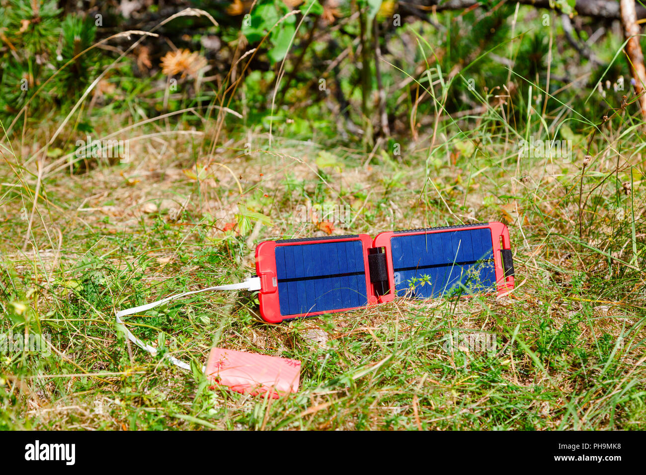 Tragbare Solarpanel lädt die Batterie eines powerbank - eine alternative Energiequelle in der wilden Konzept Stockfoto