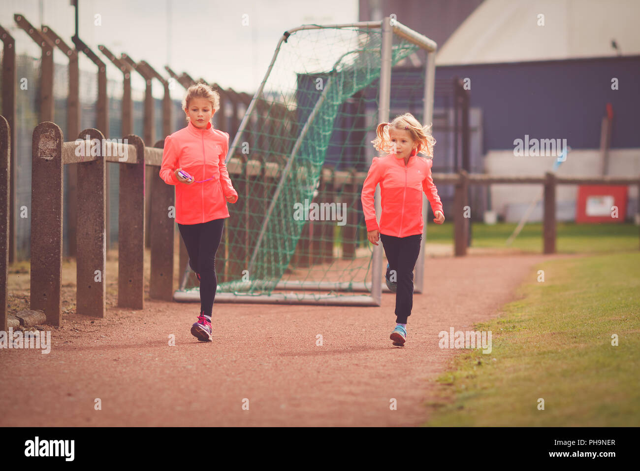 Zwei junge Mädchen laufen auf sportliche Rennstrecke Stockfoto