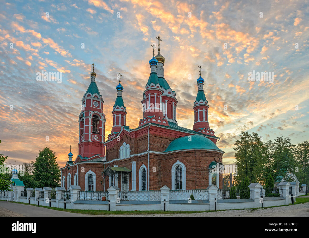 Russische Kirche über brennenden Sonnenuntergang Stockfoto