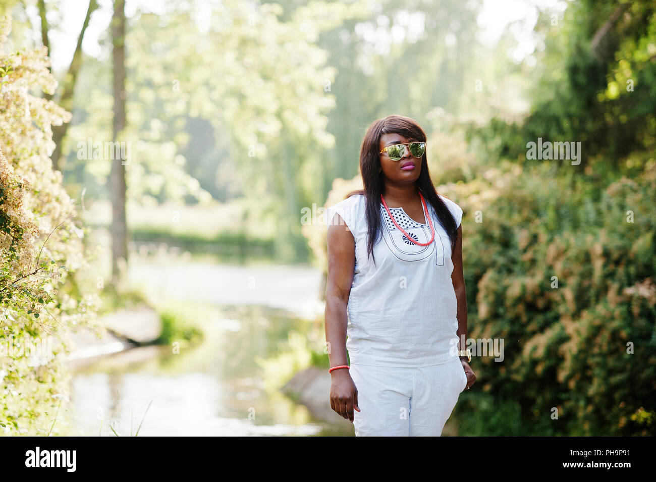 Afrikanerin am nationalen weiße Kleidung und Sonnenbrillen Stockfoto