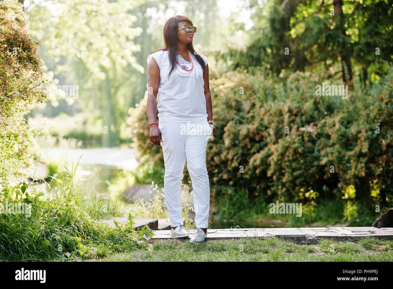 Afrikanerin am nationalen weiße Kleidung und Sonnenbrillen Stockfoto