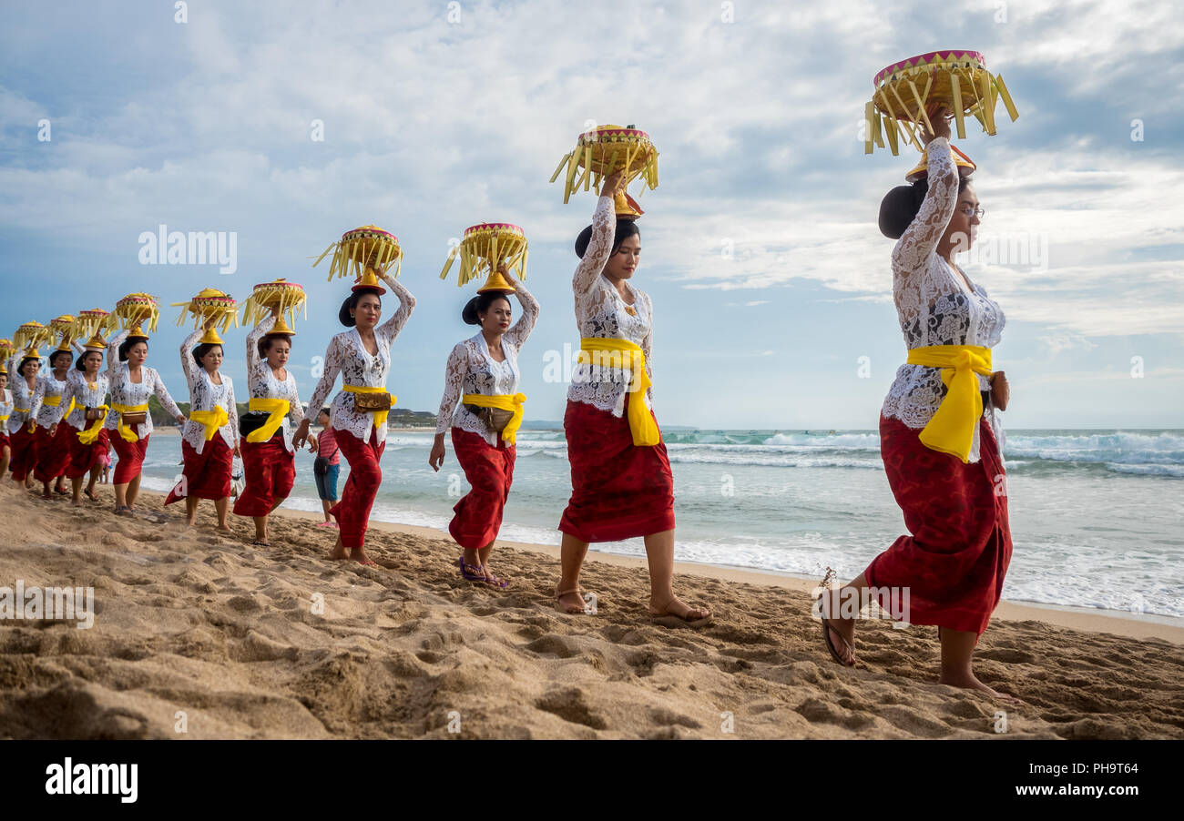 Eine Linie der balinesischen Frauen, die Angebote auf ihre Köpfe an Melasti, der größte der Erde Reinigung Zeremonie in Bali, 3 Tage vor nyepi. Stockfoto