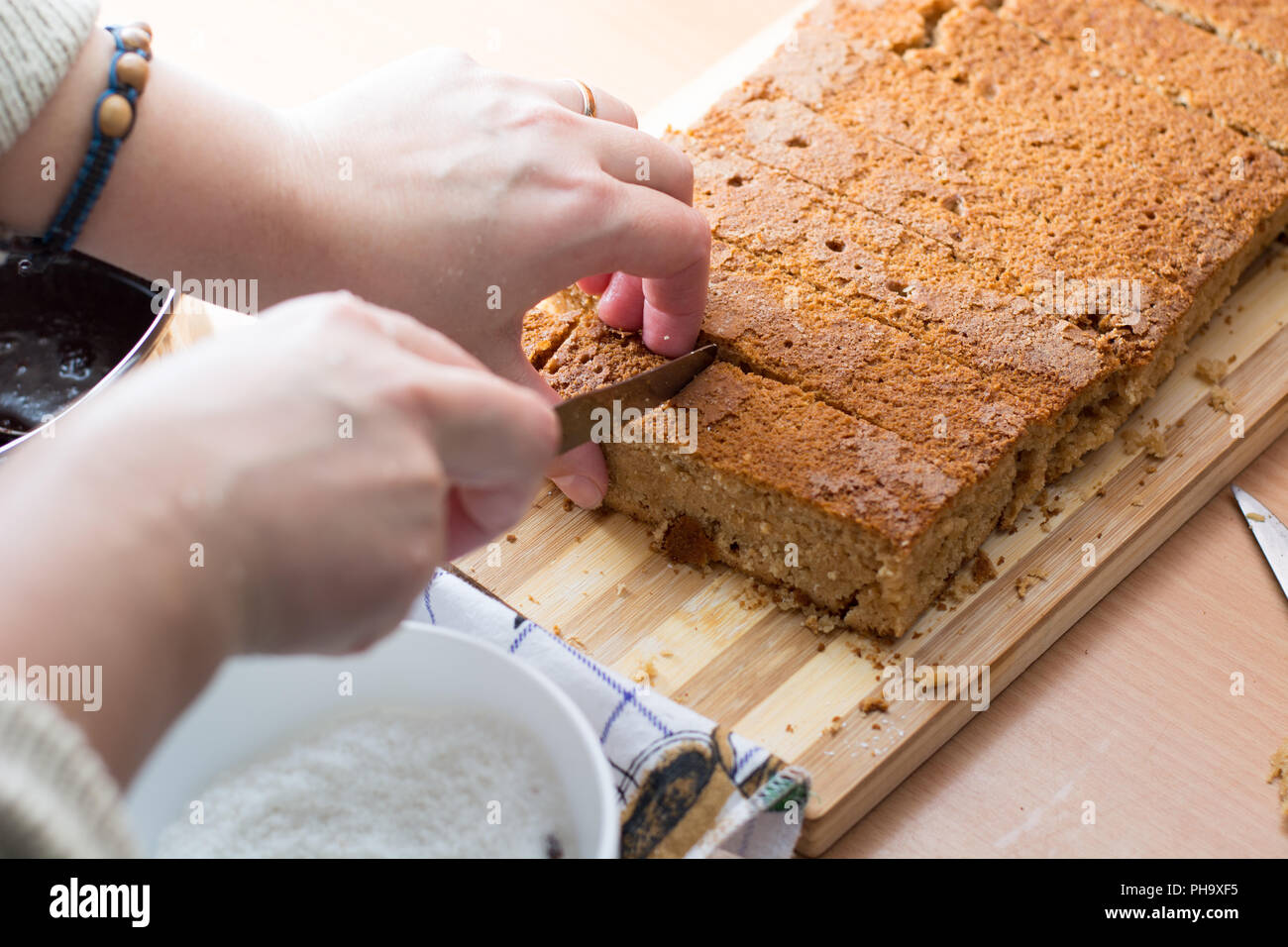 Weibliche Hände schneiden und vorbereiten Kuchen Kruste Stockfoto