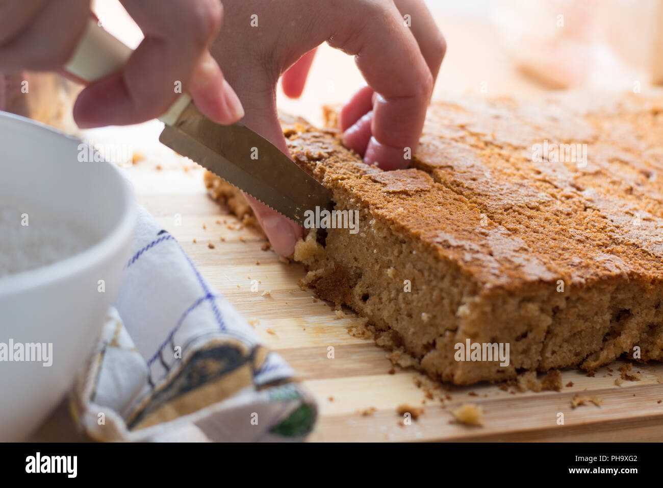 Weibliche Hände schneiden und vorbereiten Kuchen Kruste Stockfoto