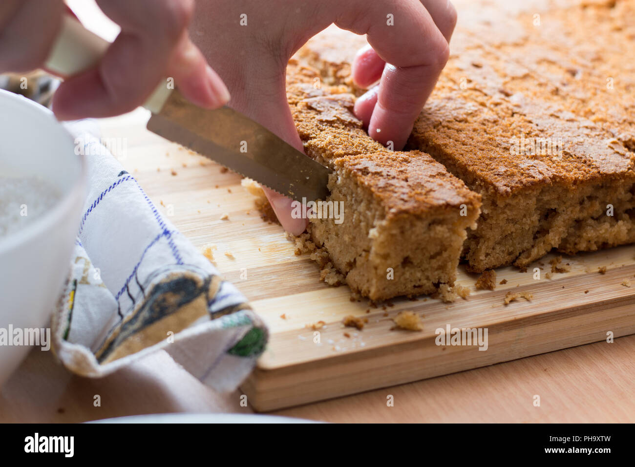 Weibliche Hände schneiden und vorbereiten Kuchen Kruste Stockfoto