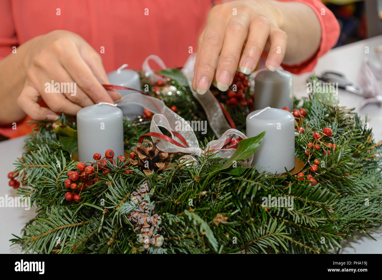 Florist schmückt Adventskranz - Nahaufnahme Weihnachten Dekoration Stockfoto
