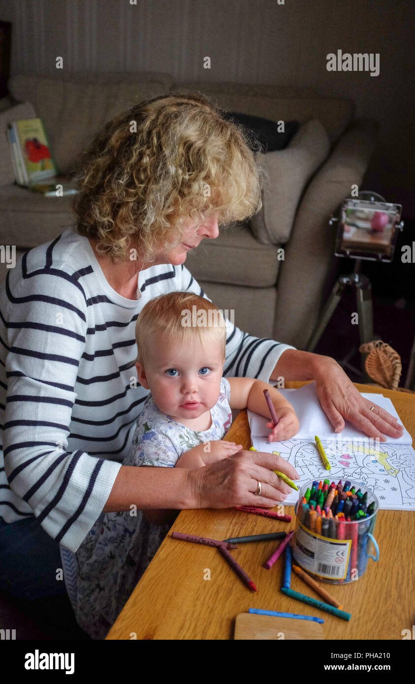 Junge Frauen Mädchen Kind bei 20 Monate alten genießen selbst zeichnen mit Buntstiften mit ihrer Großmutter Stockfoto