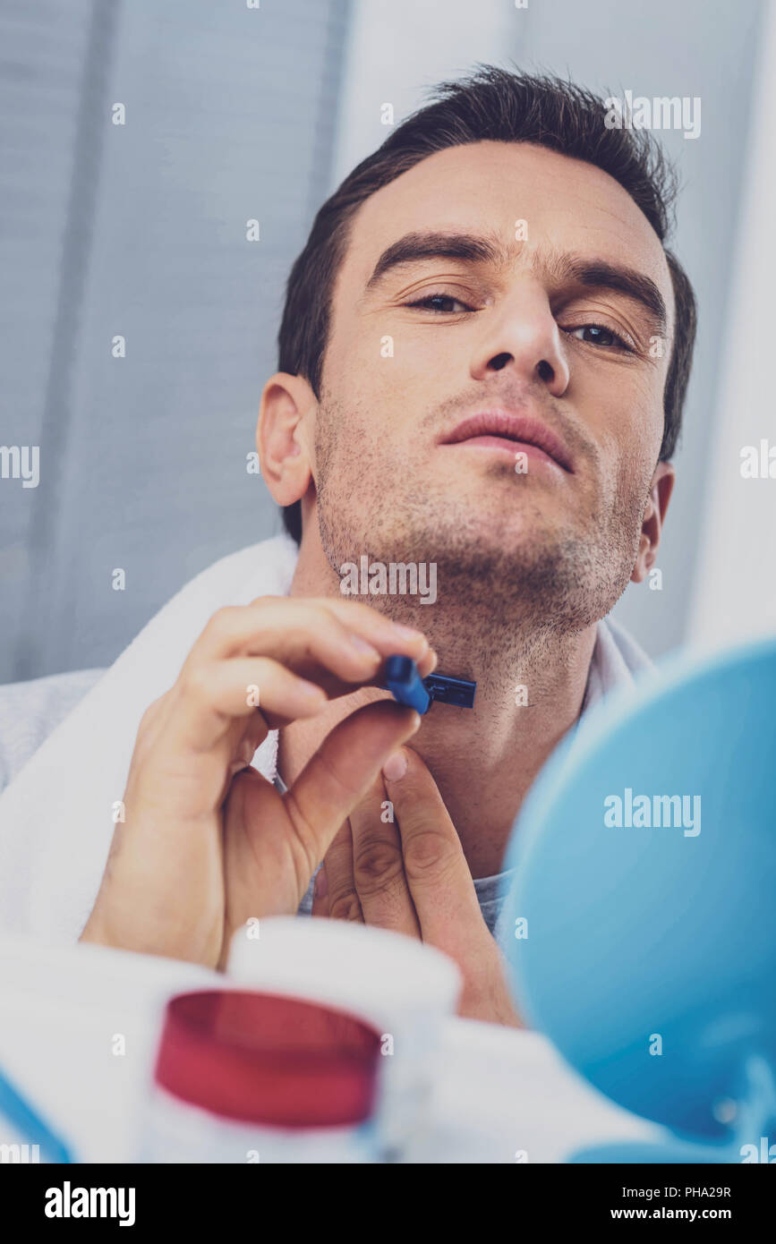 Mann rasieren Gesicht gewissenhaft stehend im Bad Stockfoto
