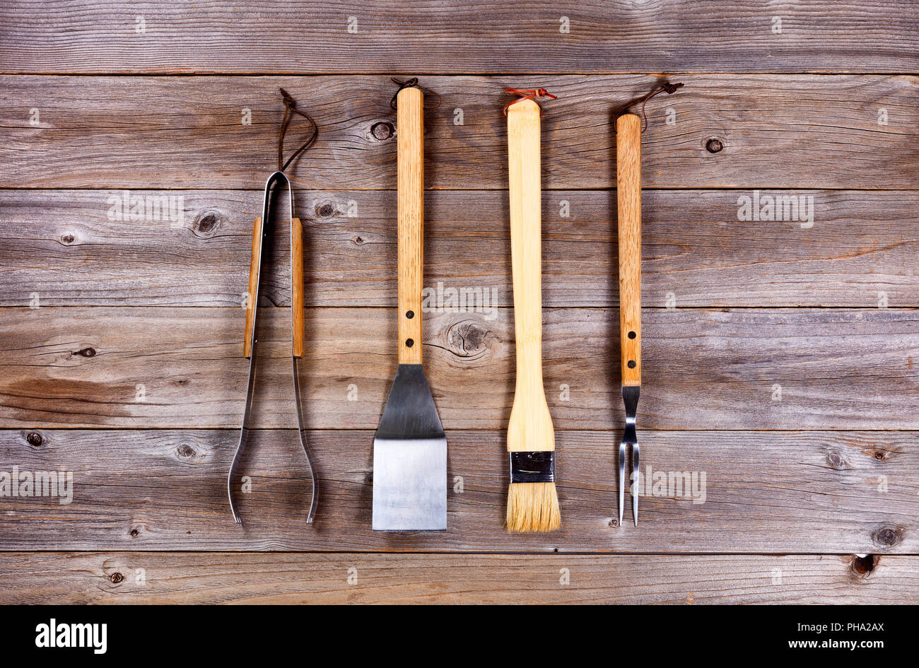 Verwendeten Küchenutensilien für Grill kochen auf rustikalem Holz Stockfoto