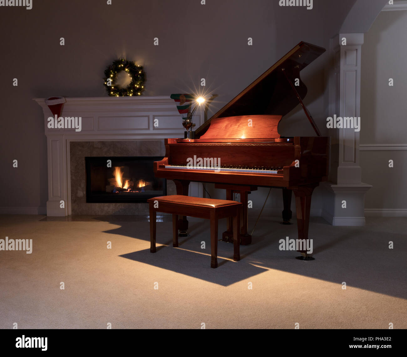 Klavier mit Leselampe und glühenden Kamin während der Ferienzeit Stockfoto