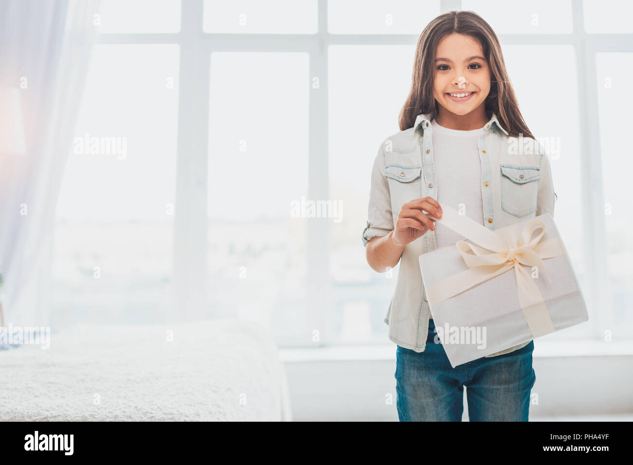 Ansprechende Kind stehen in der Nähe von Big Licht Fenster Stockfoto