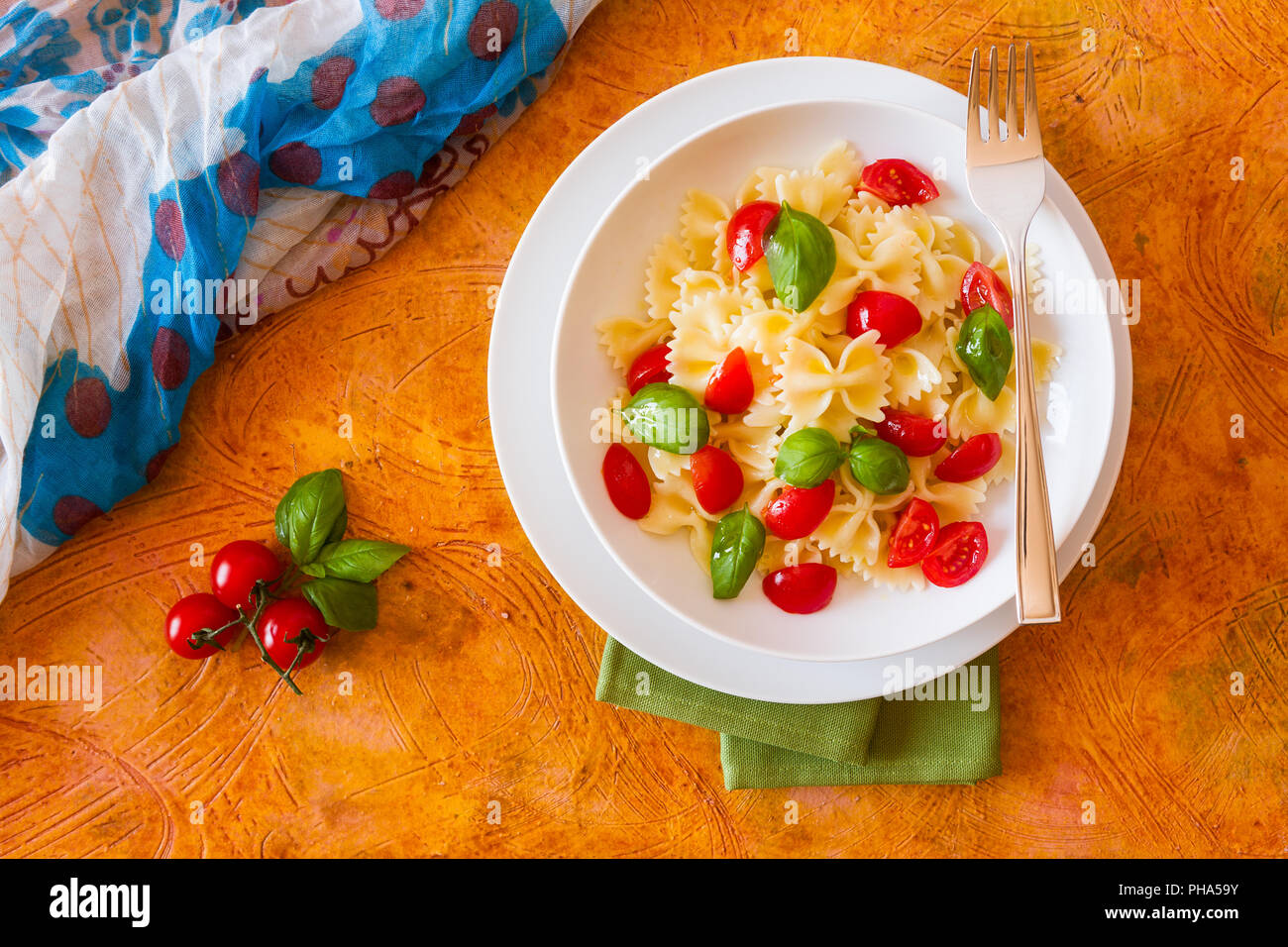 Farfalle Nudeln mit Kirschtomaten und Basilikum von oben gesehen Stockfoto