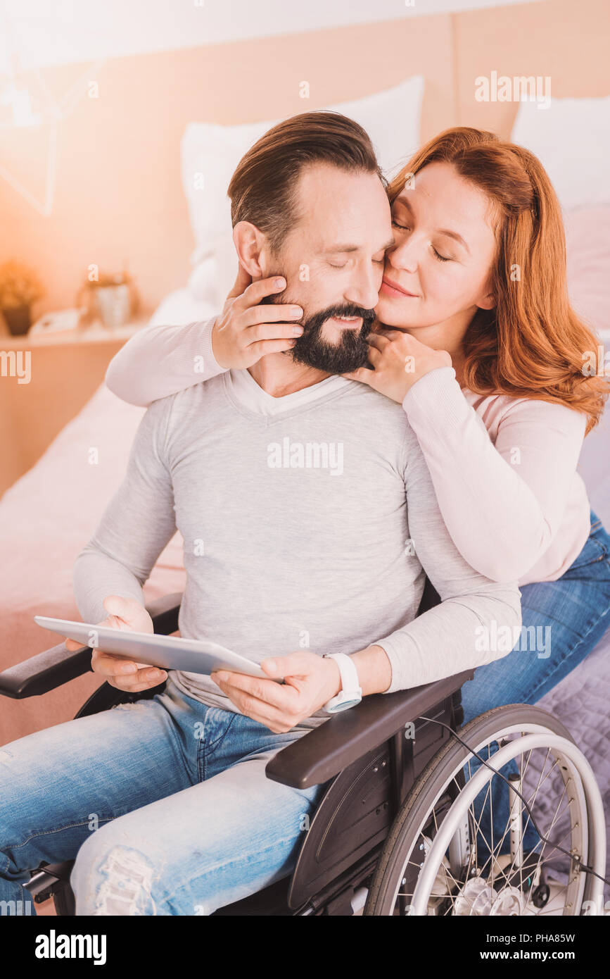 Liebevolle wheelchaired Mann Liebe auszudrücken mit seinem Ehemann Stockfoto