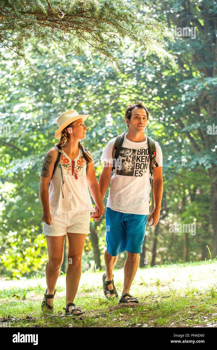 Touristen Paar mit Rucksäcken zu Fuß entlang einer Straße auf einer Sommerreise. Stockfoto