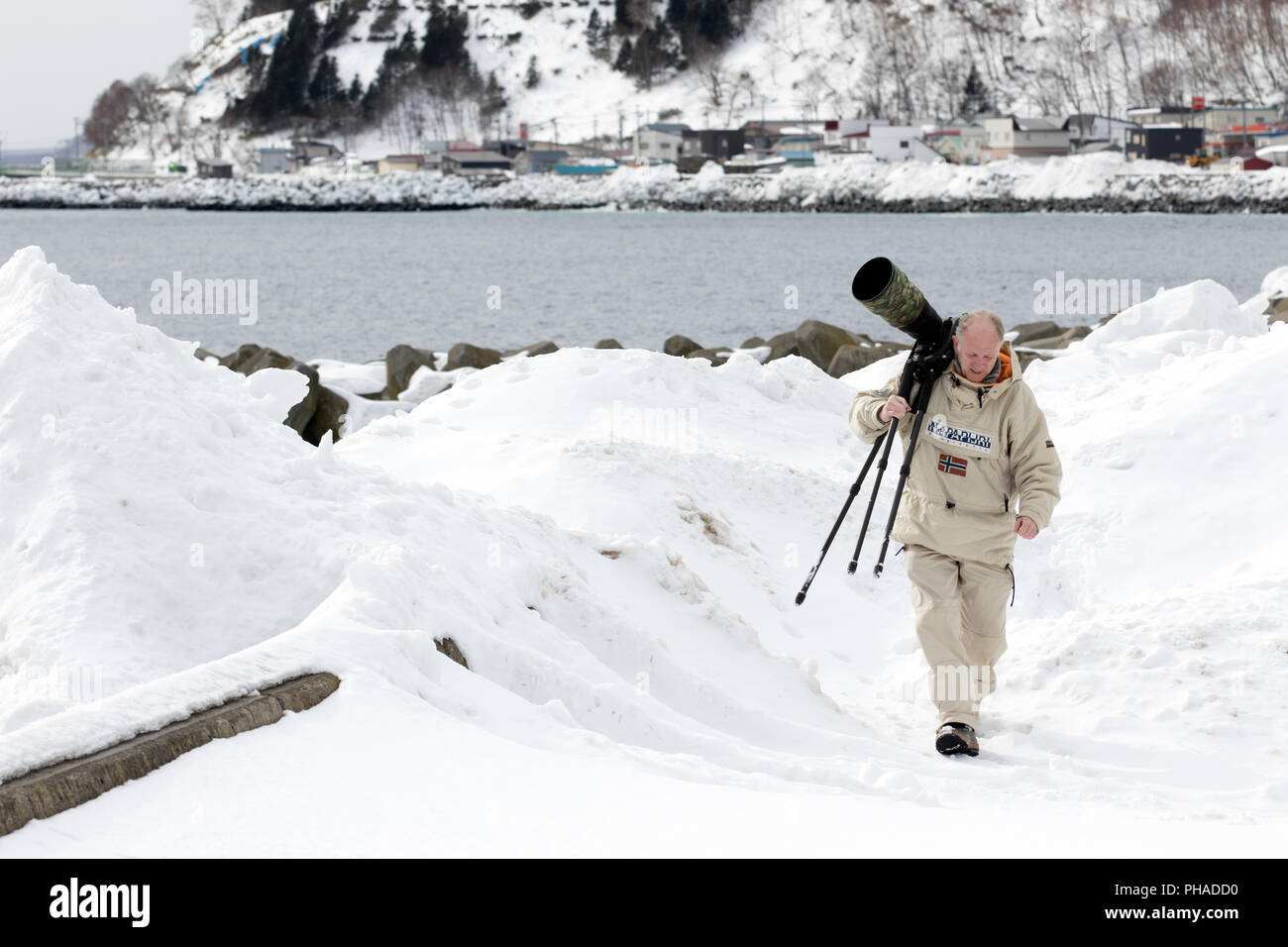 Fotograf mit einem großen Objektiv (600 mm) im Schnee Stockfoto