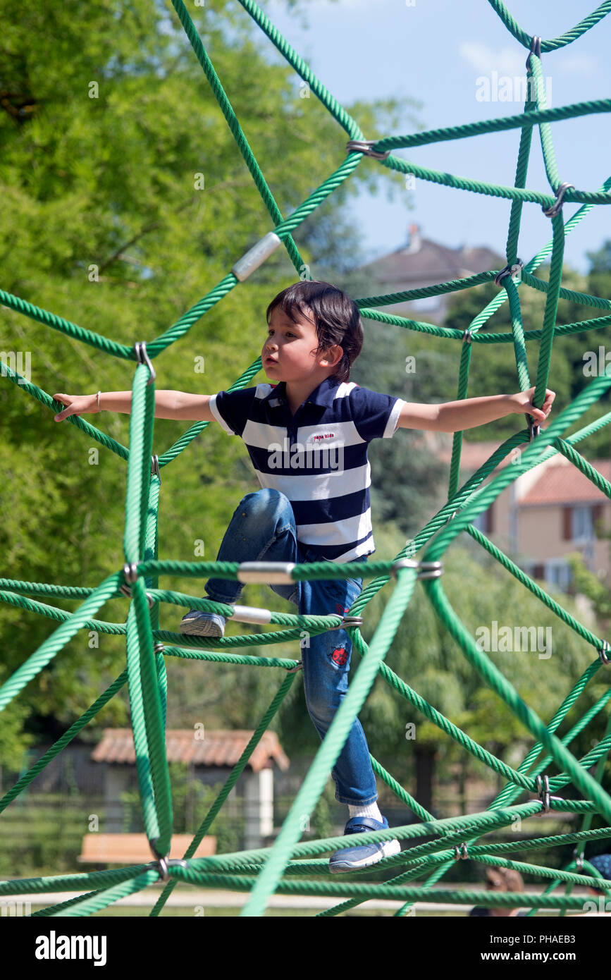 Kinder spielen auf einem Spinnennetz, Frankreich Stockfoto
