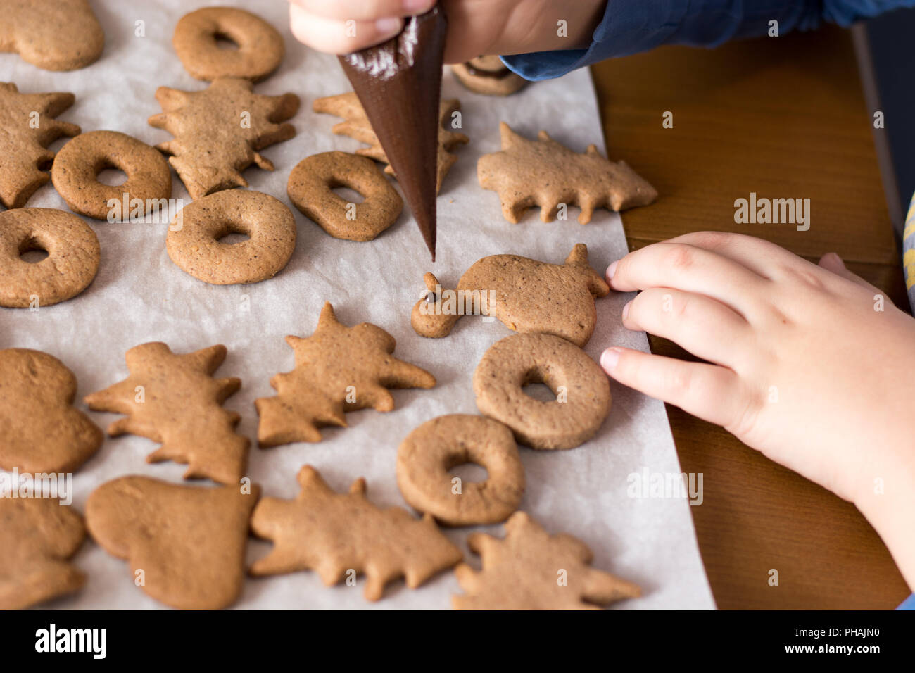 Junge dekorieren Lebkuchen Kekse mit Schokolade Stockfoto