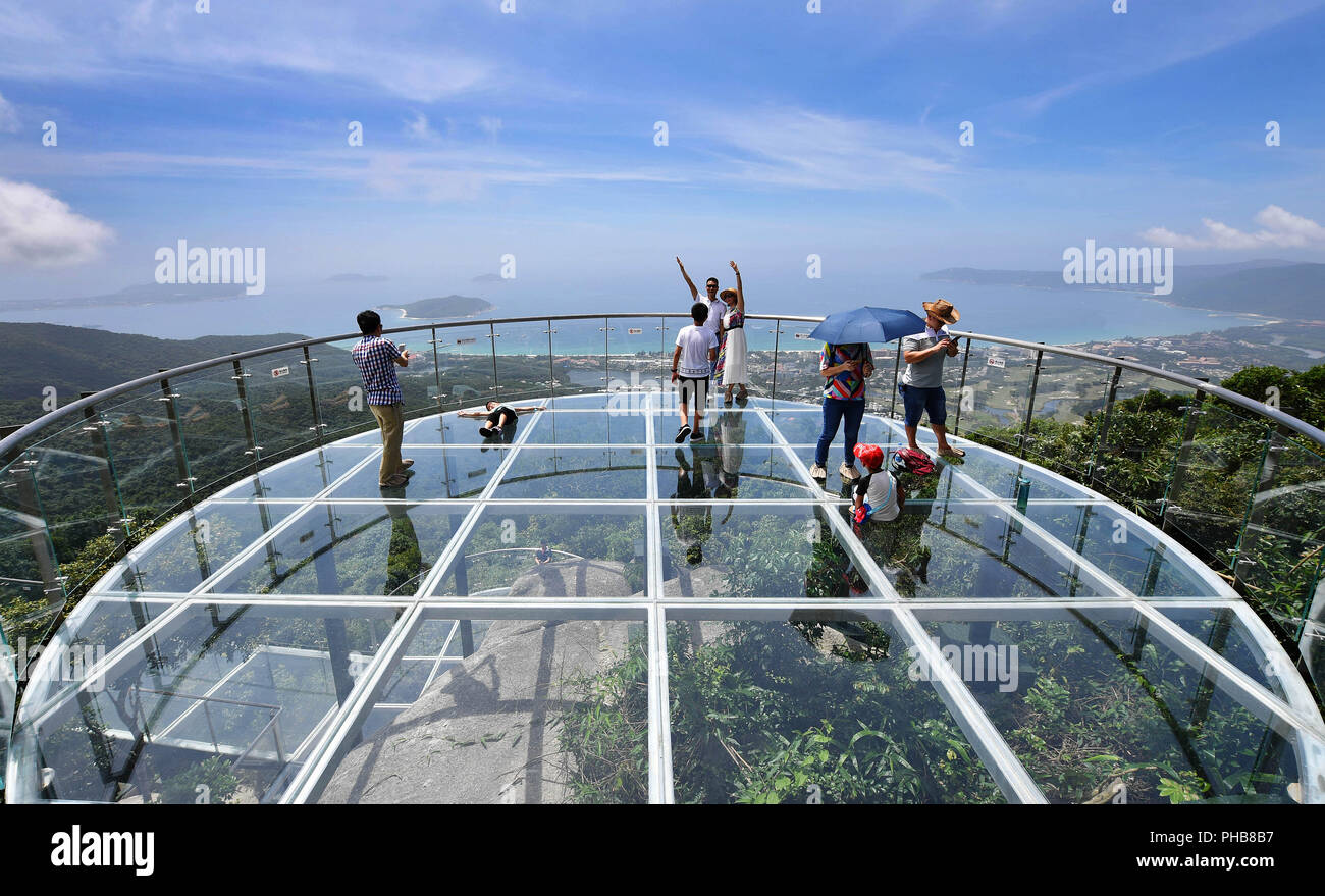 Sanya, China Hainan Provinz. 31 Aug, 2018. Touristen gehen Sightseeing auf  dem Glas Aussichtsplattform, ein Teil eines mit Meerblick Glas Skywalk am  Yanlong Bay Tropical Paradise Forest Park in Sanya, South China