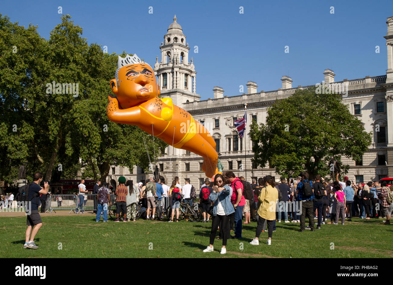 Einen riesigen Ballon mit der Darstellung der aktuellen Londoner Bürgermeister Sadiq Khan ein helles Gelb bikini über den Houses of Parliament in Westminster geflogen werden. Stockfoto
