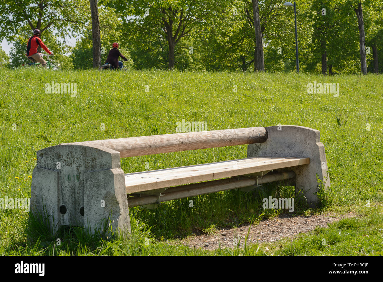 Massives Holz - Stein Bank in einem Park lädt zum Rest Stockfoto