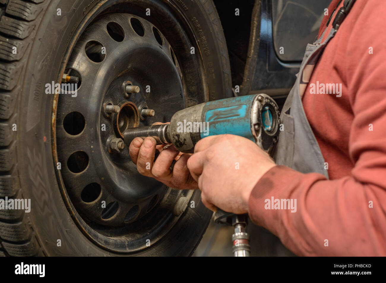 Mechaniker beim Reifenwechsel mit einem Schlagschrauber Stockfoto