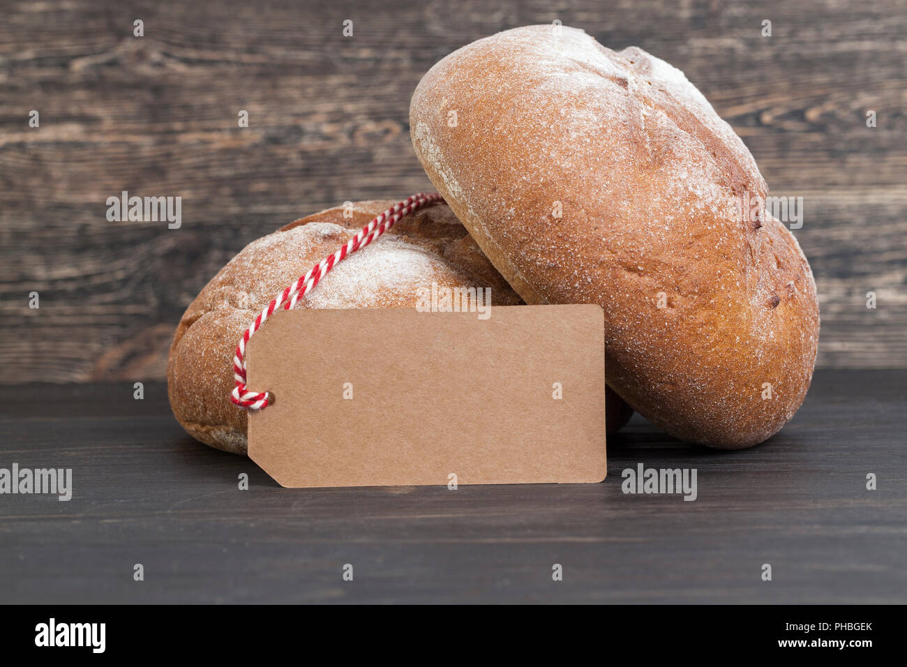 Zwei neue runden Laib Roggen dunkles Brot auf einem Schwarzen Tisch, Nahaufnahme, Tags für Preis- oder andere Inschriften Stockfoto