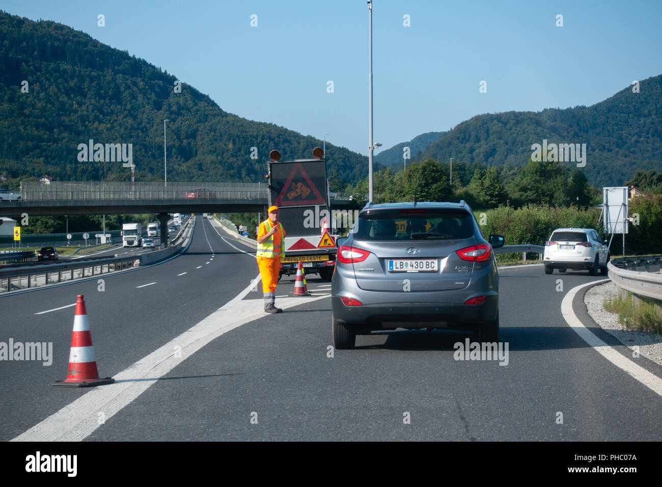 Roadworker Autos umleiten Autobahn an der Straßensperre aufgrund von Unfällen Stockfoto