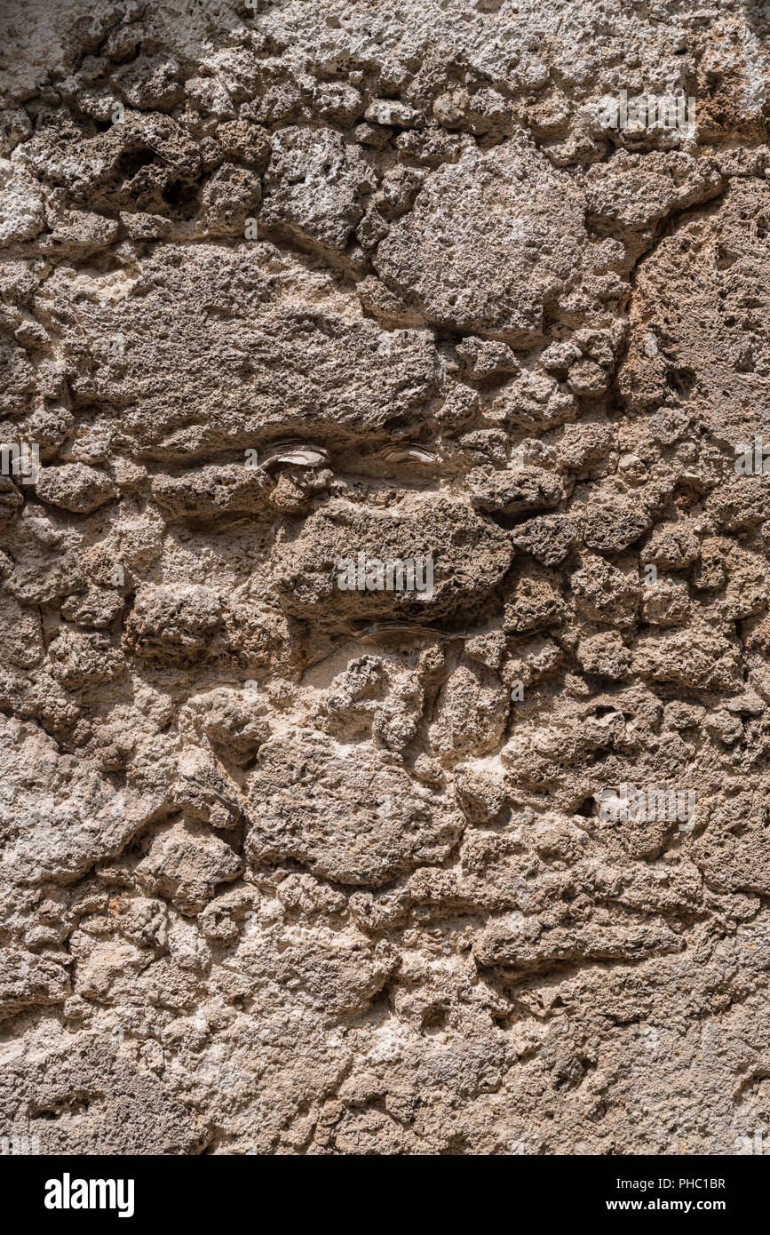 Rauhe Oberfläche einer historischen Mauer aus Stein - in der Nähe Stockfoto