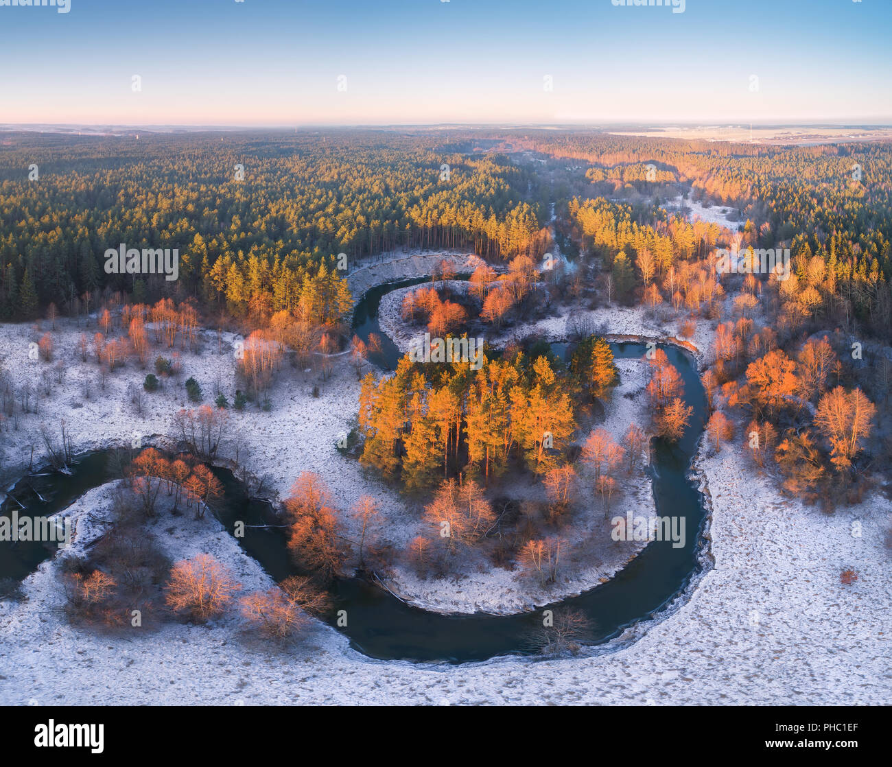 Antenne Winter sonnige Landschaft. Wicklung Fluss im Wald Blick von oben. Art malerischen Hintergrund. Stockfoto