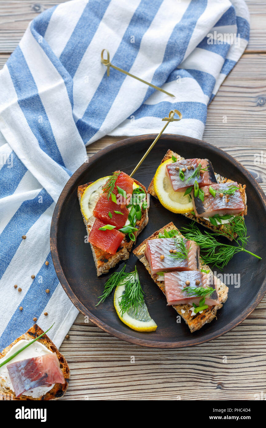 Geröstetes Brot mit Hering, Kaviar und Grüns. Stockfoto