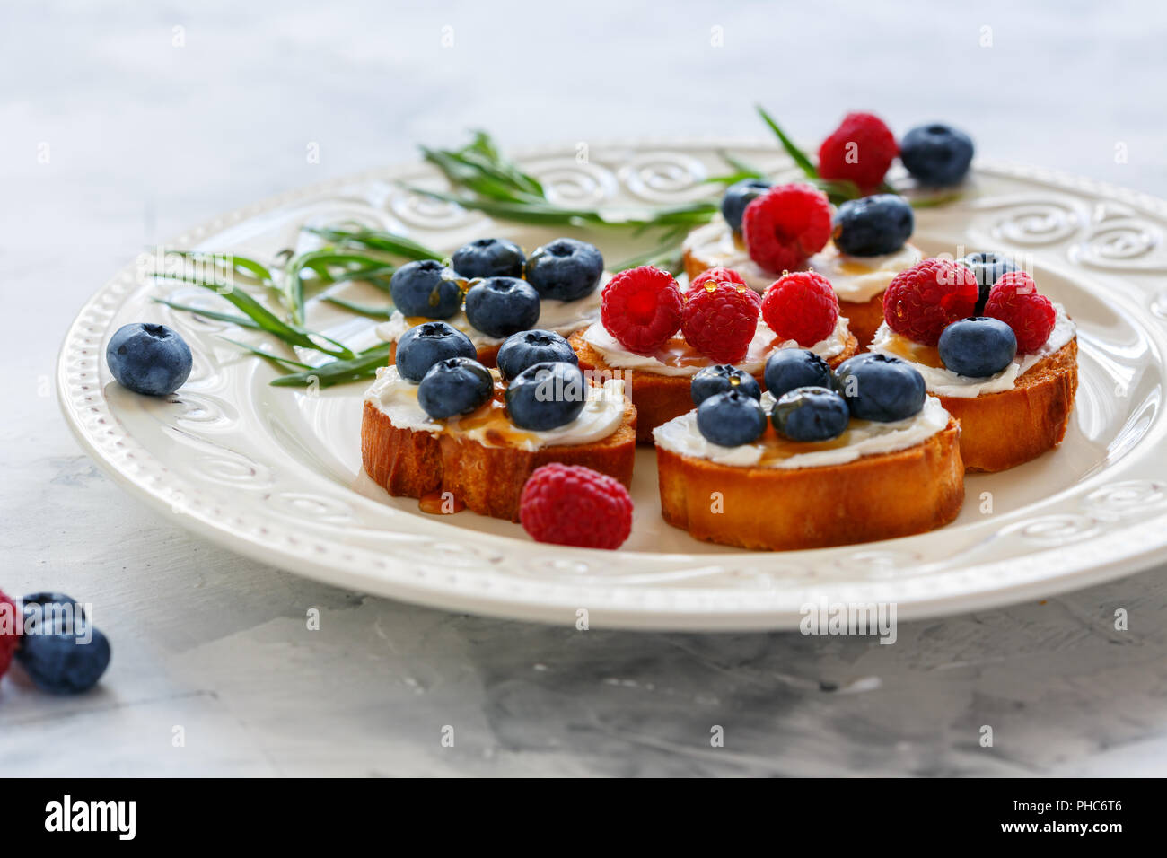 Berry crostini auf einem weißen Teller. Stockfoto