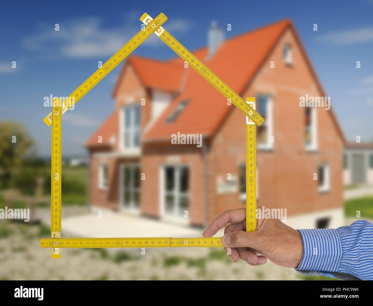 Haus zum Verkauf mit real estate agent Holding yard Stick Stockfoto