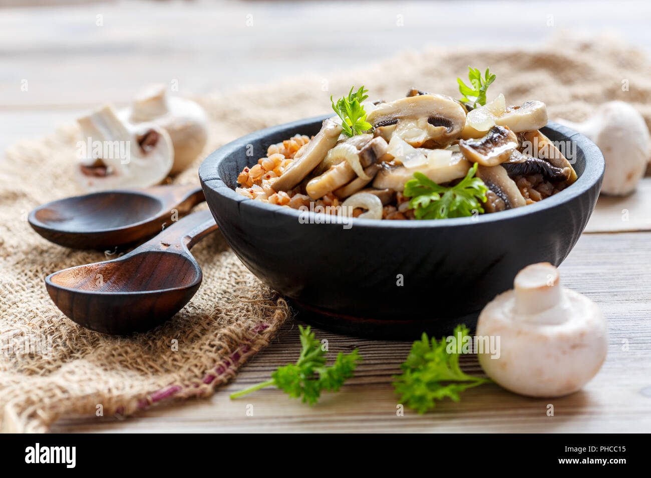 Buchweizen Brei mit Pilzen und Zwiebeln in eine hölzerne Schüssel. Stockfoto