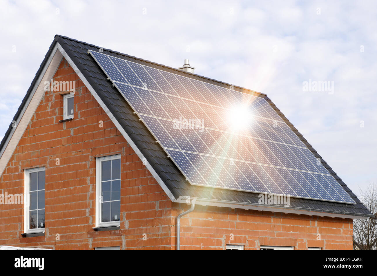 Sonnenkollektoren auf Wohn- Dach mit Sonnenstrahlen Stockfoto