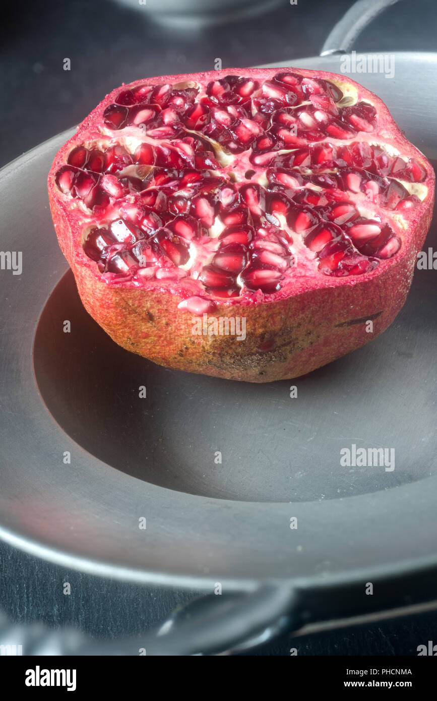 Granatapfel, halbierte Frucht, Zinn Schüssel Stockfoto