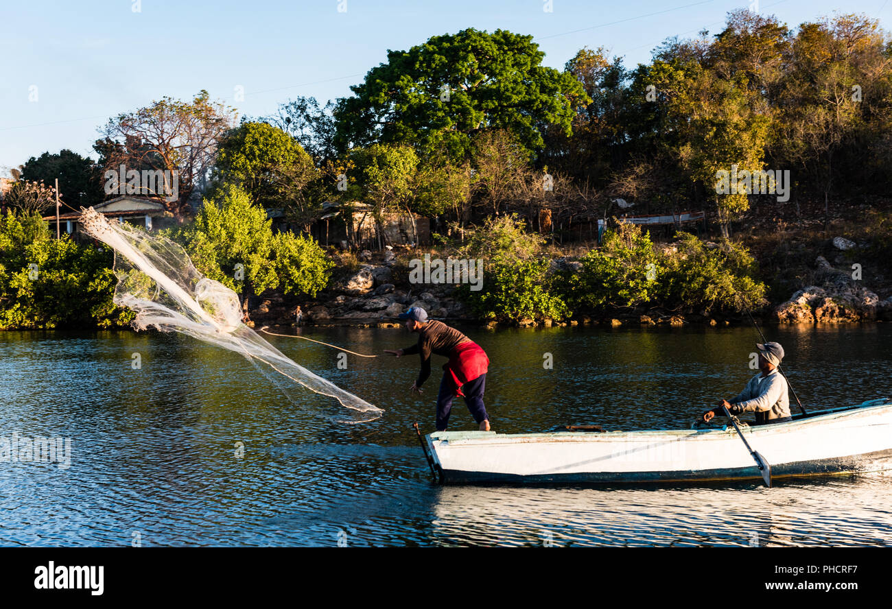 Kubanische Fischer fangen Meeresfrüchte mit der herkömmlichen Methode der Casting hand Net in den Ozean vom Ruderboot. Stockfoto