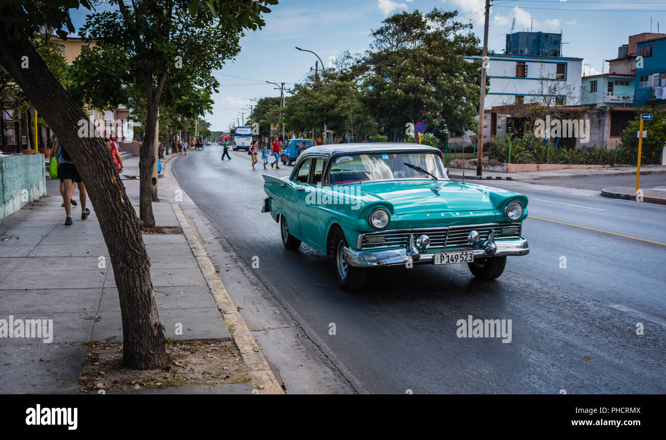 50s style Auto mit überstehenden Scheinwerfer und scharfen Kühlrippen entlang reiten in der ruhigen Vendado Nachbarschaft von Havanna, Kuba. Stockfoto