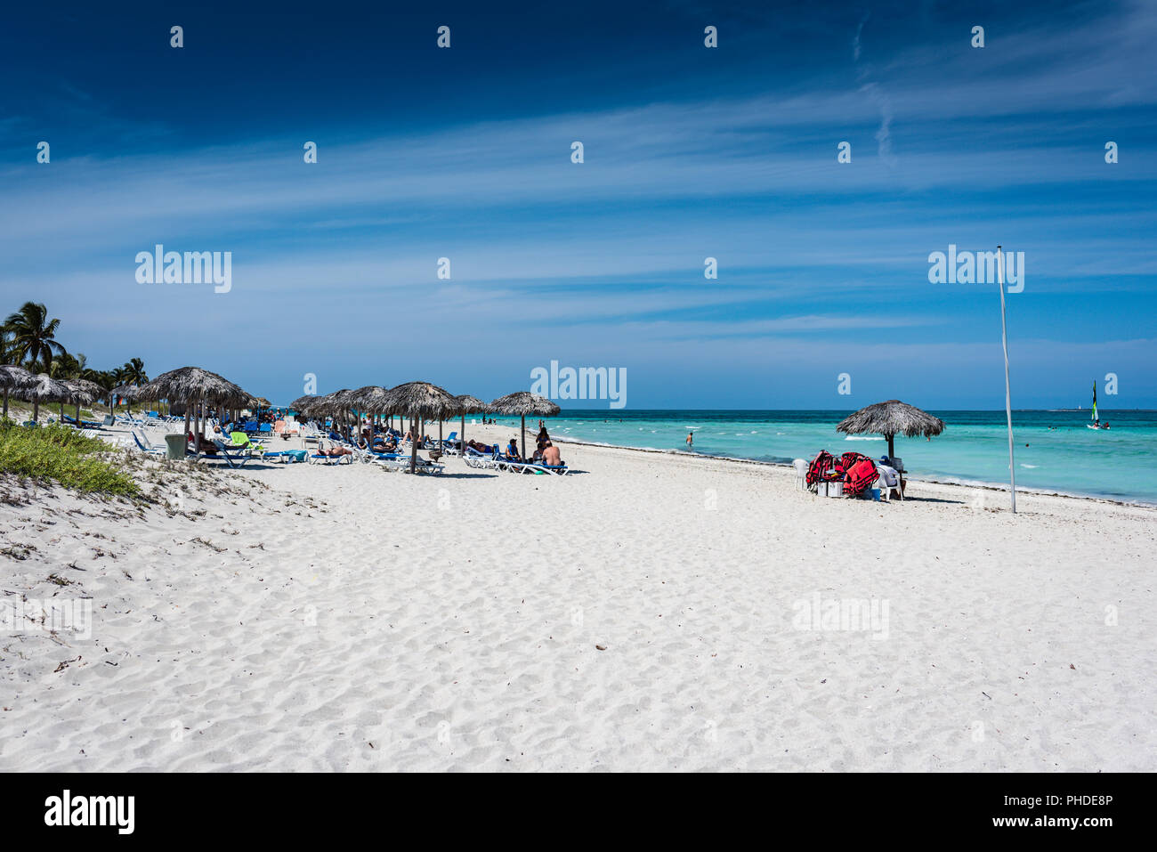 Varadero, Kuba/März 17, 2016: Resort Gäste genießen im Schatten des Grases überstieg Sonnenschirme am Strand. Stockfoto