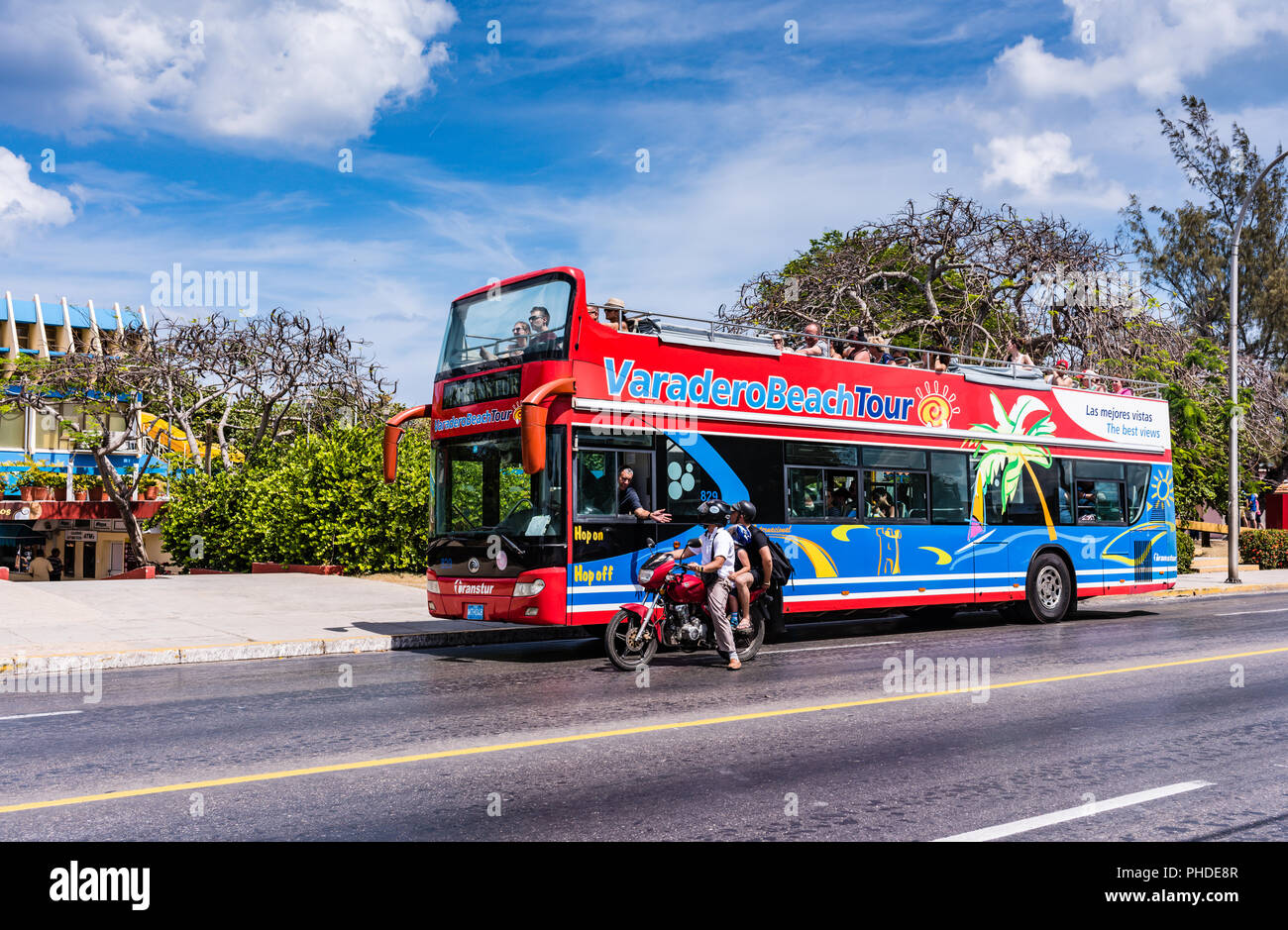 Varadero, Kuba/19. März 2016: Doppel Decker Tour bus und Familie auf einem Motorrad cruisen die Varadero Strand der Stadt. Stockfoto