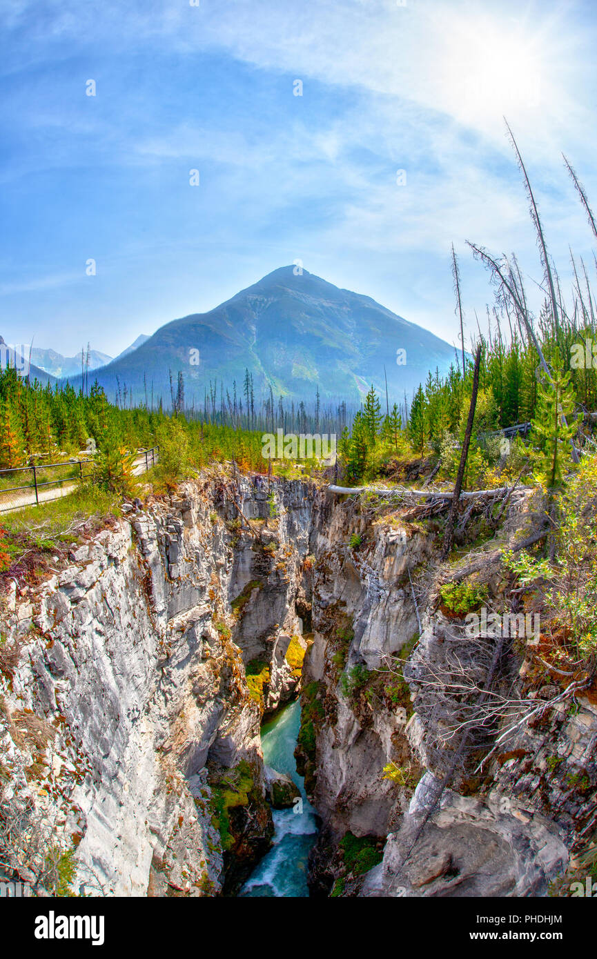 Wasser aus Tokuum Creek unterhalb der tiefen und engen Marble Canyon mit Zinnoberrot Peak im Hintergrund bei Kootenay National Park in British Columbia, Stockfoto