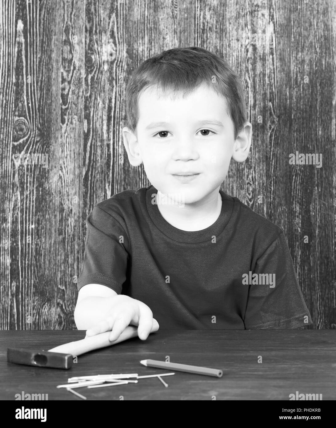 Junge in ein T-Shirt, Gebäude, Werkzeuge, Hammer und Nägel, close-up Schwarzweiß Schwarzweiß-portrait Stockfoto