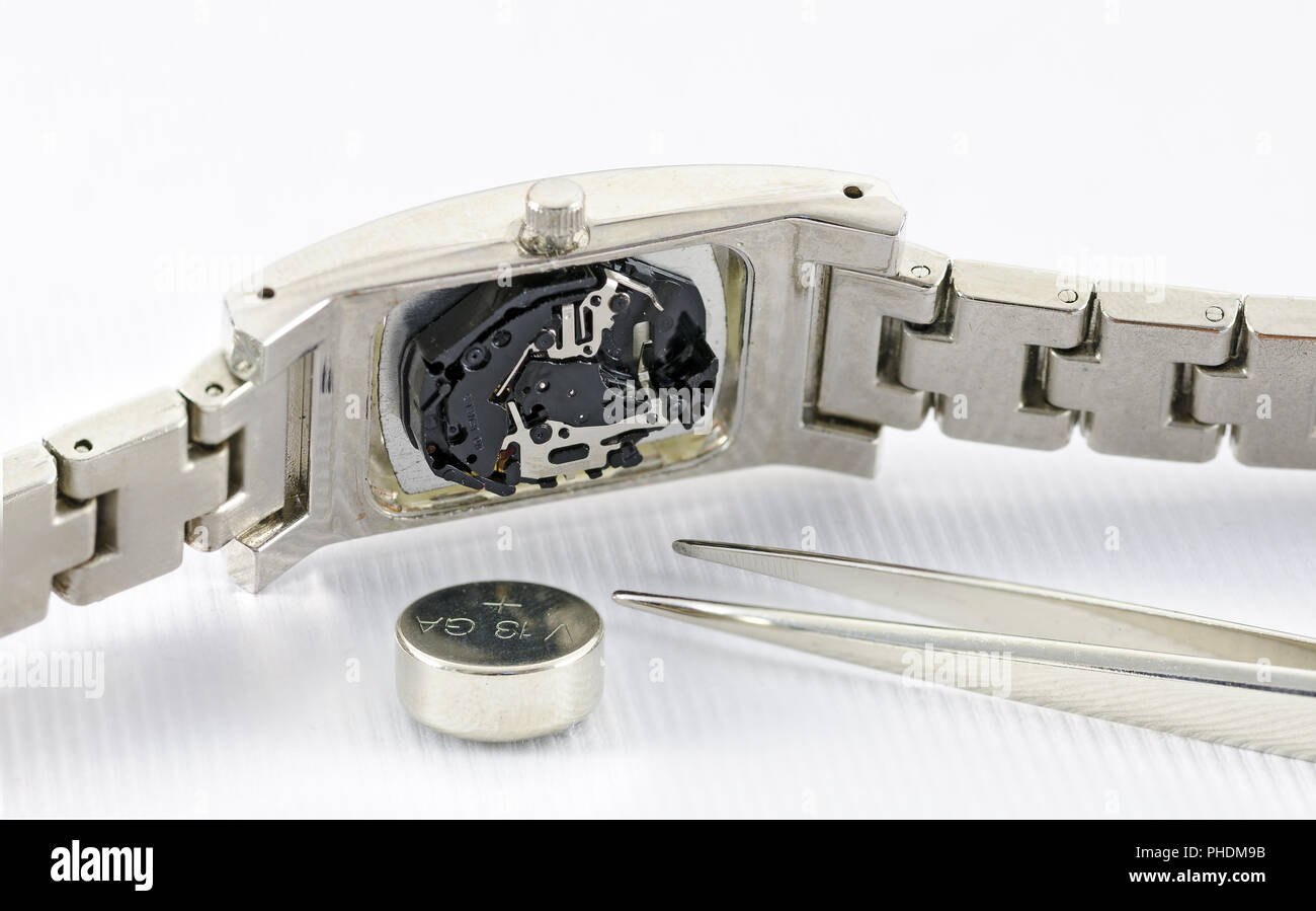 Armbanduhr mit Knopfzelle und Pinzette Stockfoto