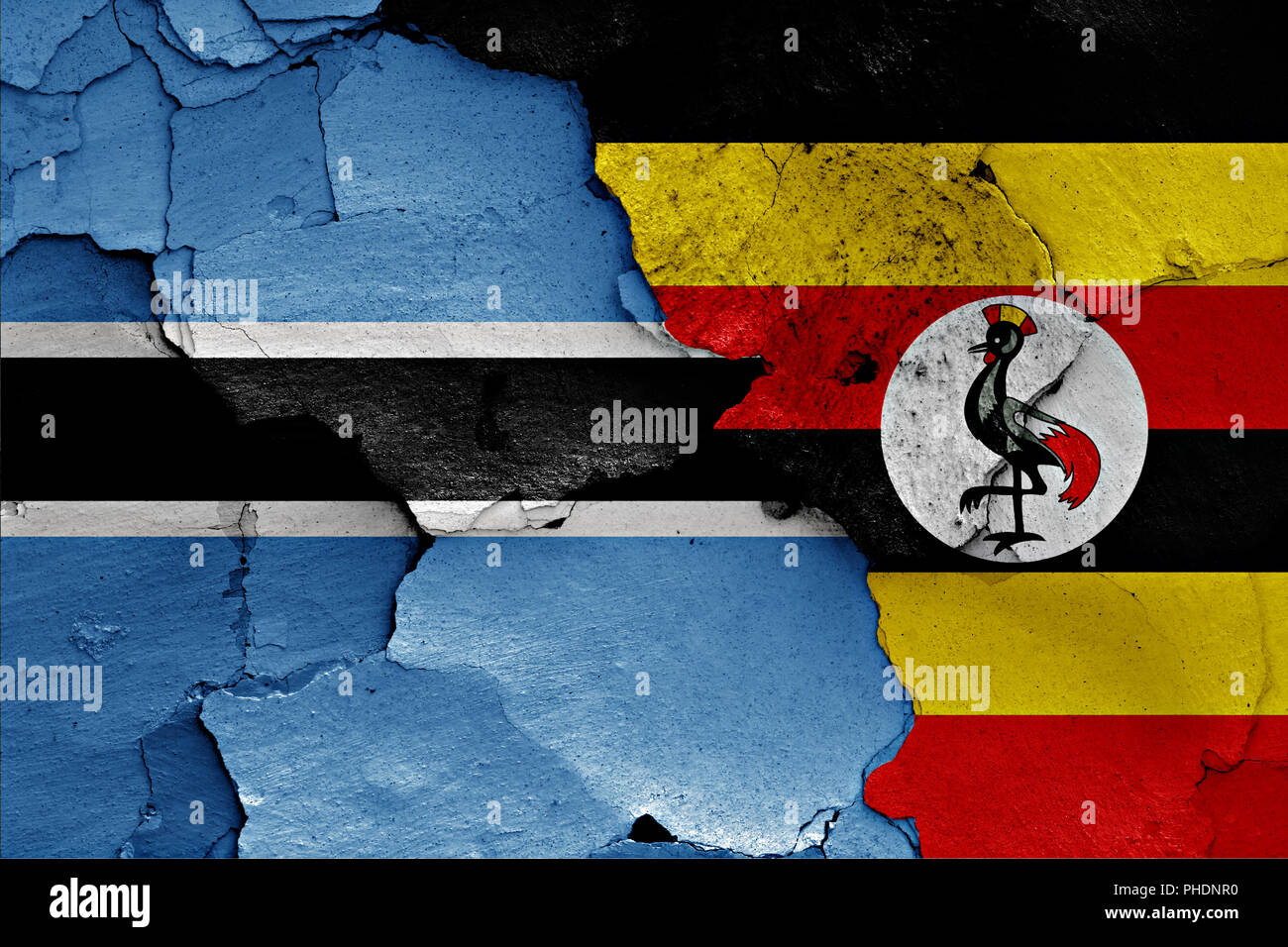 Flagge von Botswana und Uganda auf gerissene Wand gemalt Stockfoto