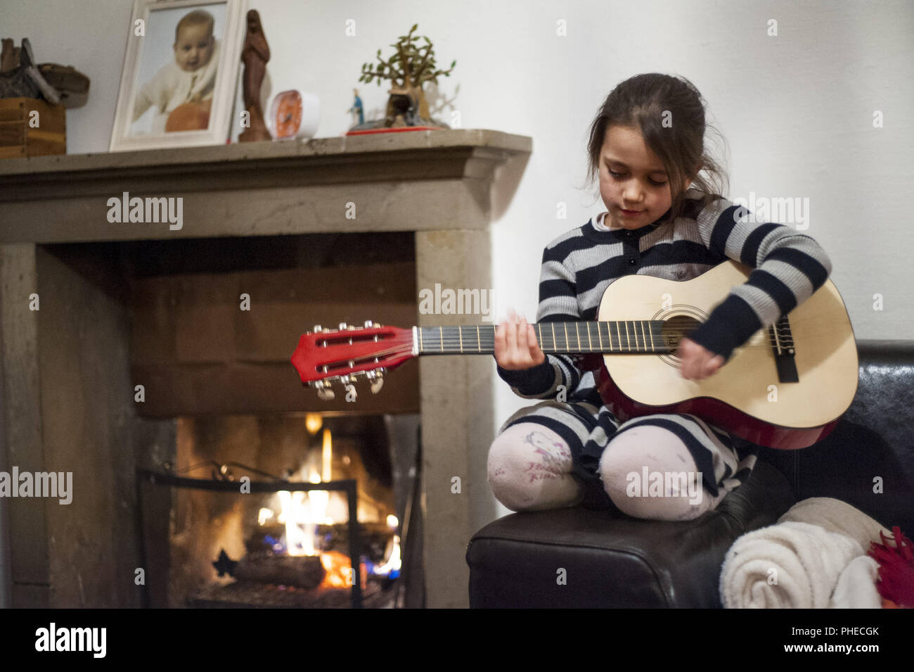 Porträt eines 6-jährigen Mädchens spielt die Gitarre Stockfoto