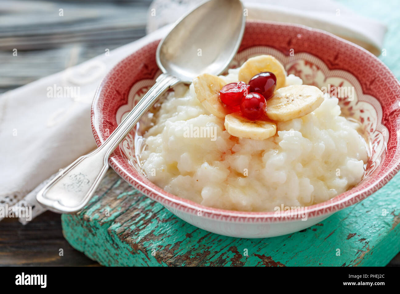 Reisbrei mit Bananen, Beeren und Honig. Stockfoto
