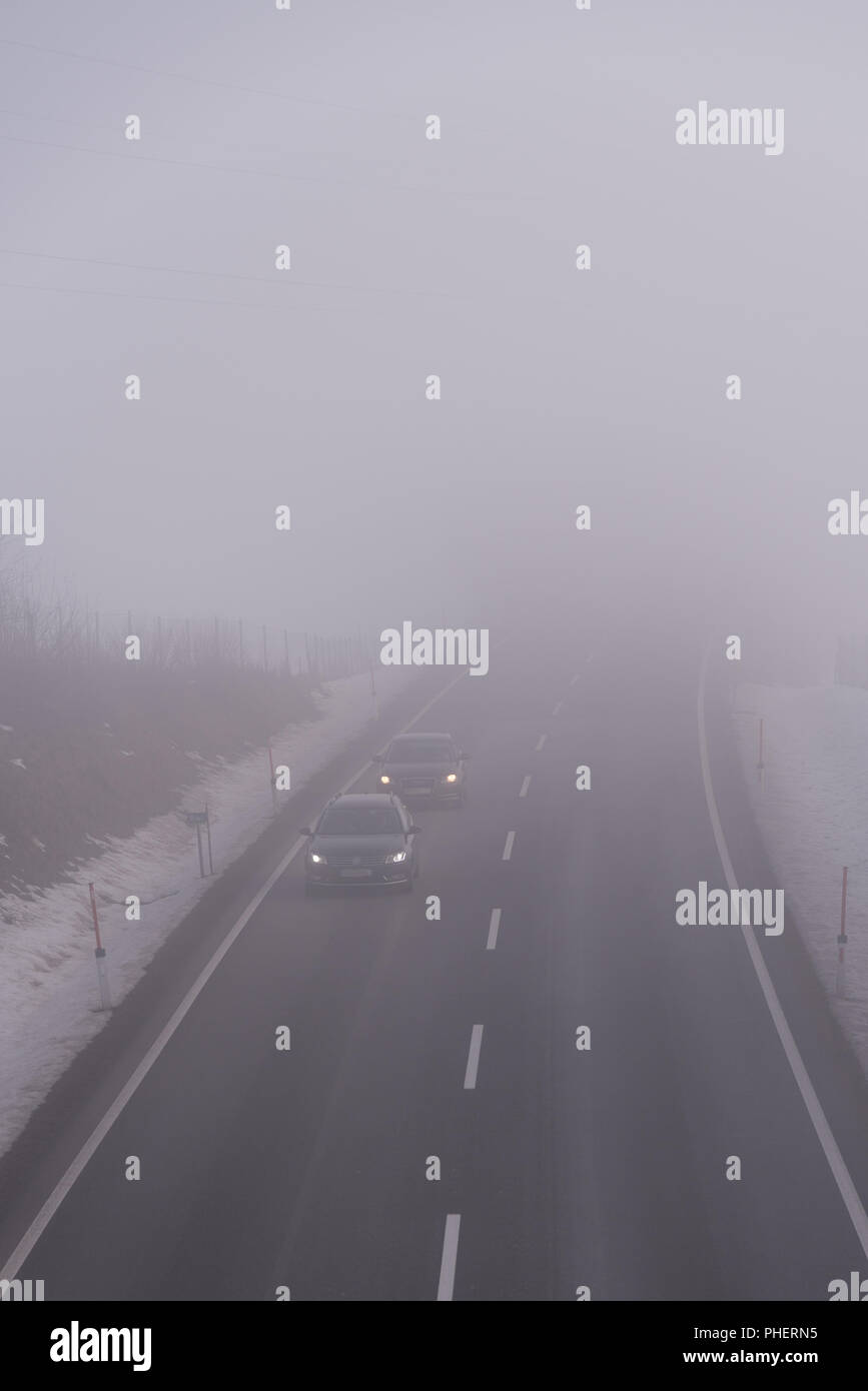 Schlechte Sicht bei dichtem Nebel auf einer Landstraße Stockfoto