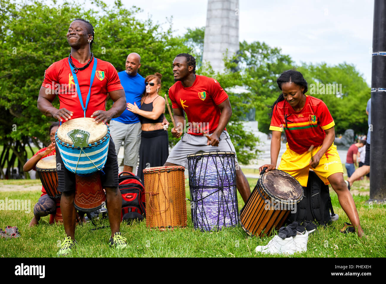 African American männlichen und weiblichen Perkussionisten spielen Djembe und Basstrommel Schlagzeug bei Tam Tams Festival in Mount Royal Park, Montreal, Quebec, Kanada. Stockfoto