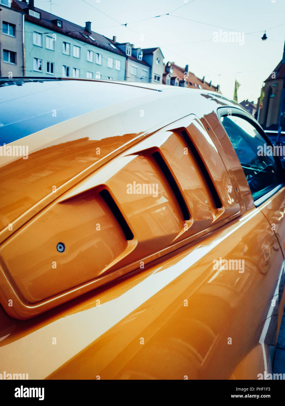 Zu sehen in der Nähe auf einem orange und schwarz Mustang in der Stadt Stockfoto